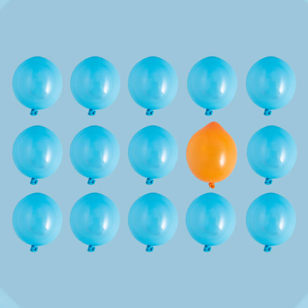 istock Pattern made of blue balloons on a light blue background with one orange balloon. Independence, individuality, individualism, creativity, uniqueness creative minimal concept. 1333372199