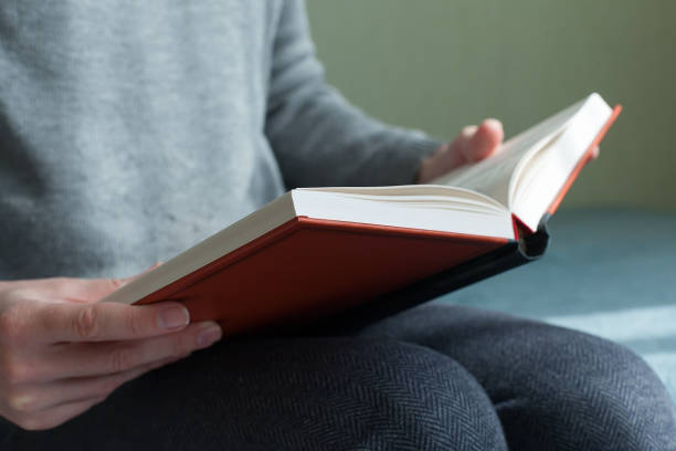 istock Young man opening and reading a book, close up, vintage style. 1333374207