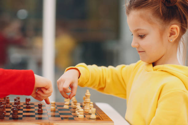 istock Little kids playing chess at kindergarten or elementary school 1333378721