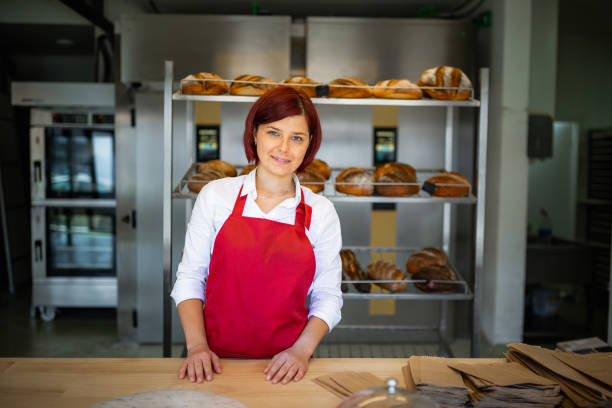 istock Beautiful young redhead female worker working in bakery. 1333384009