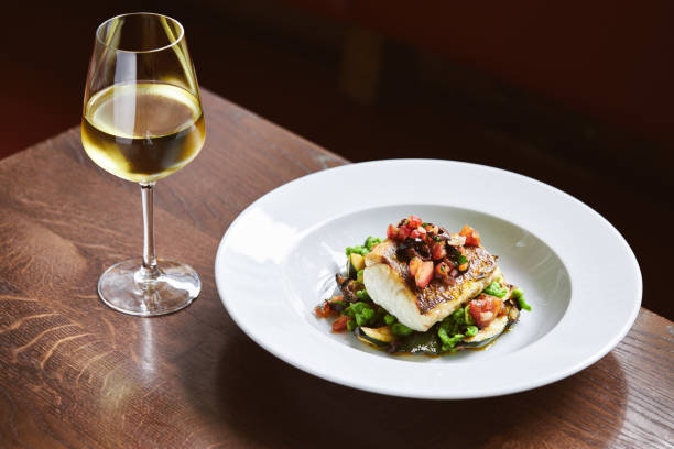 White wine and cod dish in restaurant White wine and cod dish in restaurant white wine stock pictures, royalty-free photos & images