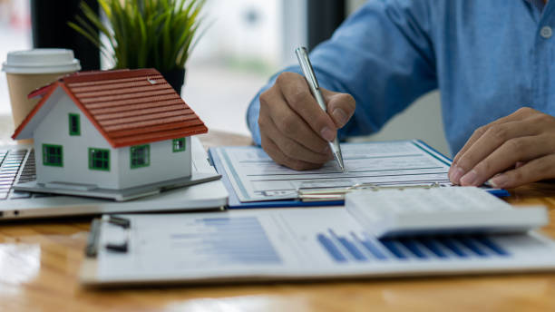 istock Sales representatives work at the desk with home purchase contracts or on office loans and interest rates. 1333388020