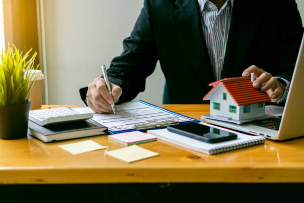 sales representatives work at the desk with home purchase contracts or on office loans and interest rates. - real estate imagens e fotografias de stock