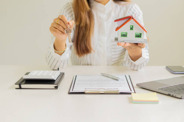 sales representatives work at the desk with home purchase contracts or on office loans and interest rates. - real estate imagens e fotografias de stock