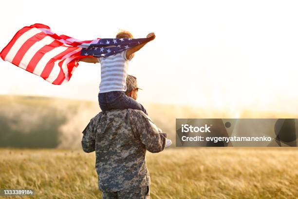 Excited Child Sitting With American Flag On Shoulders Of Father Reunited With Family Stock Photo - Download Image Now