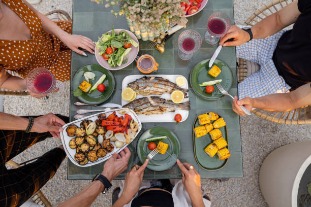 istock People eating grilled vegetables and fish, top view 1333389302