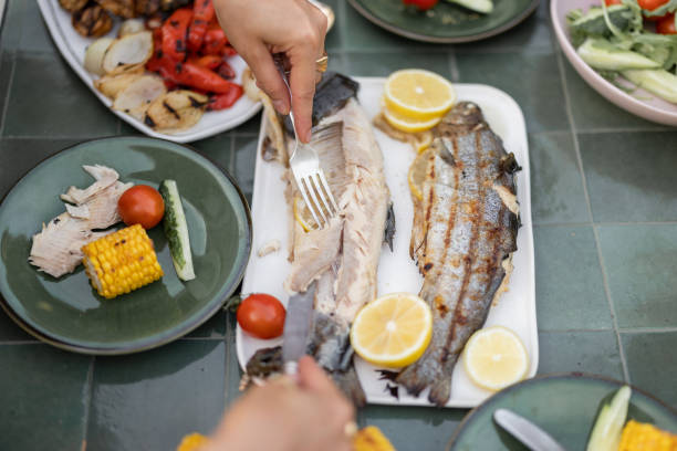 istock Eating grilled fish and vegetables, close-up 1333389352