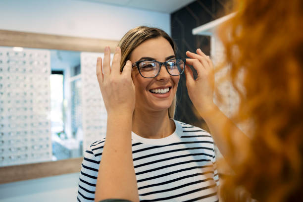 Now try this one Woman trying on eyeglasses in optical store optical instrument stock pictures, royalty-free photos & images