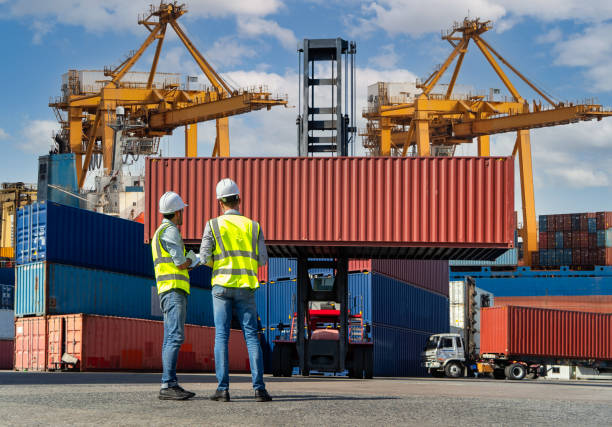 istock Engineers are overseeing the transportation of cargo with containers inside the warehouse. Container in export and import business and logistics. 1333391549