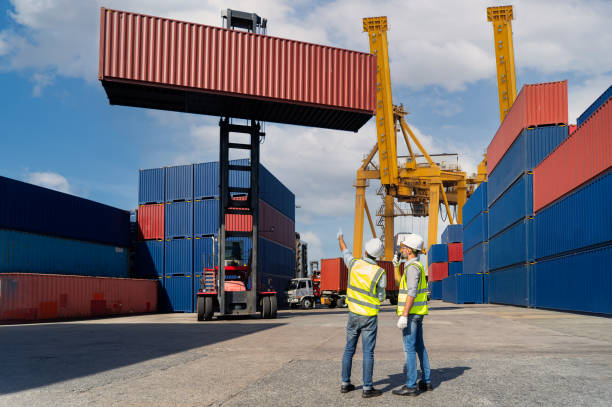 istock Engineers are overseeing the transportation of cargo with containers inside the warehouse. Container in export and import business and logistics. 1333391558