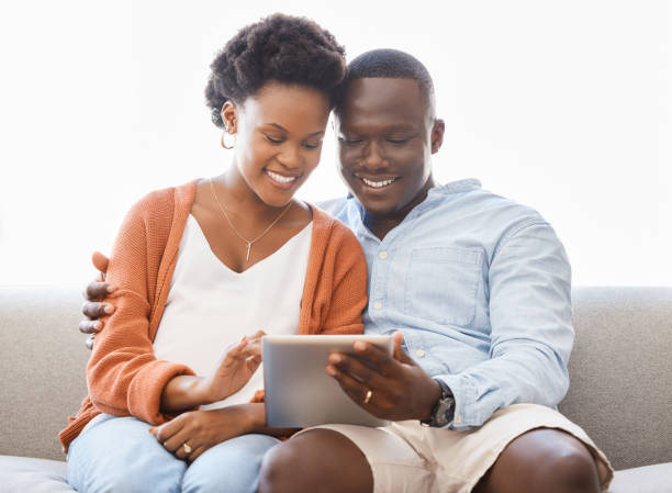 istock Shot of a young couple sitting on the couch while using a digital tablet at home 1333391702