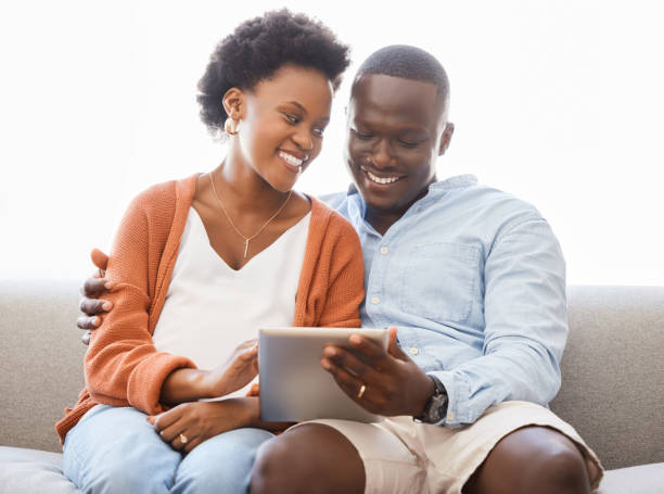 istock Shot of a young couple sitting on the couch while using a digital tablet at home 1333391713