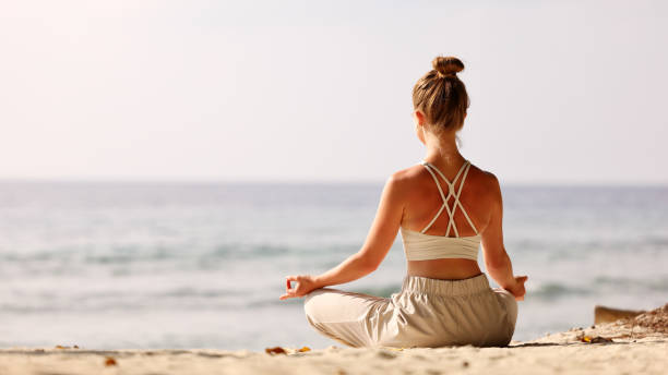 istock Calm woman meditating on beach at sunset 1333392866