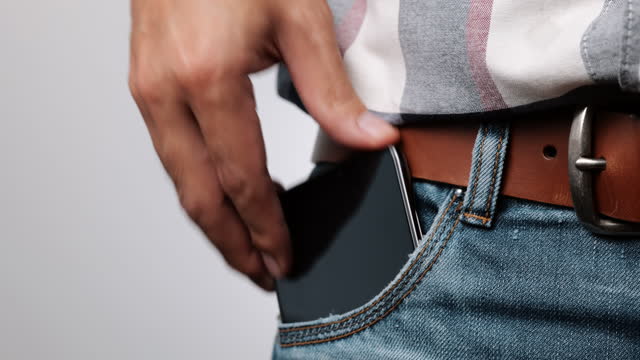 Mobile phone in denim jean pocket