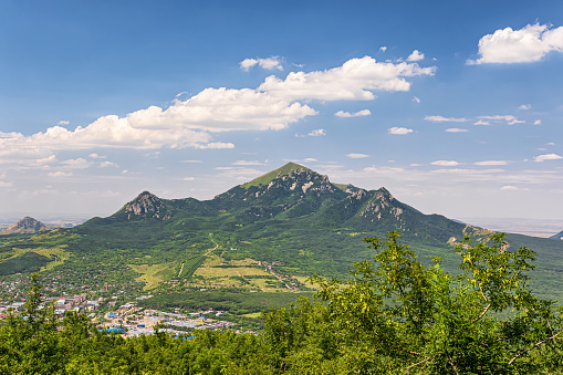 View of the Beshtau mountain, the city adjacent from below and fluffy clouds in the sky in summer
