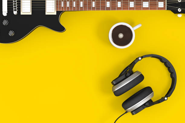 Black Electric Guitar with Headphones and Coffee Cup on a yellow background. 3d Rendering