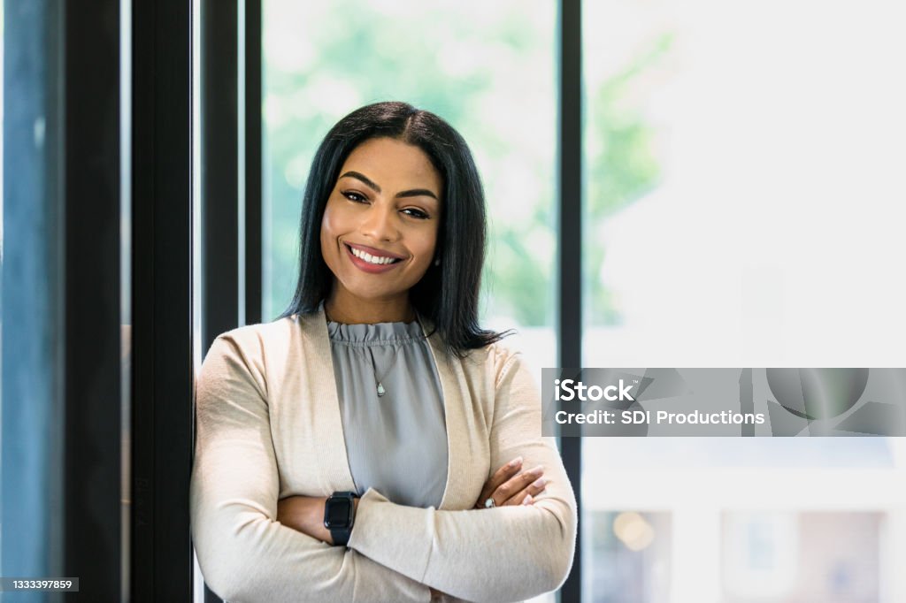 Portrait of confident, successful mid adult female CEO A confident, successful mid adult woman poses for a photo with her arms crossed.  She has a professional occupation, possibly a lawyer, administrator, senior manager, or financial advisor. Lawyer Stock Photo