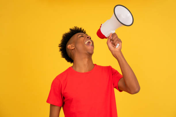 istock Afro man using a megaphone to raise his voice. 1333398013