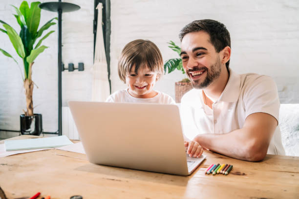 istock Little boy and his father using a laptop at home. 1333398826