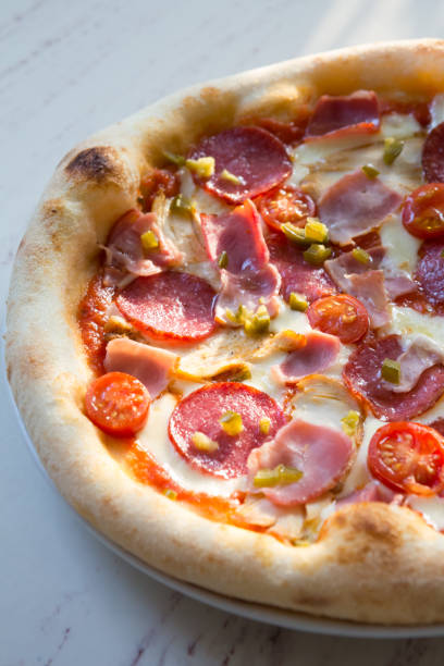 istock Whole baked neapolitan pepperoni pizza on a table 1333400160