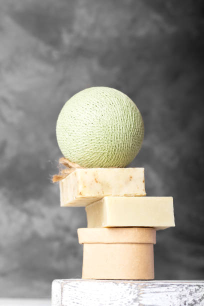 istock Handmade soap on white wooden podium on concrete background 1333400567