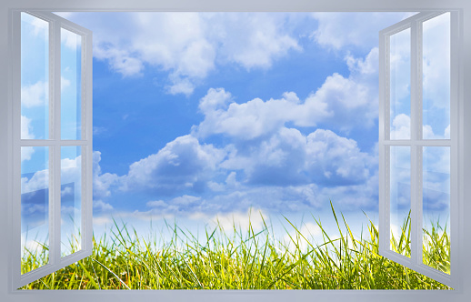 Beautiful green mowed lawn with cloudy sky on background seen through a window - concept image.