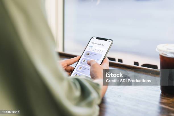 Young Adult Woman Surfs Net For Doctor Stock Photo - Download Image Now - Doctor, Searching, Using Phone