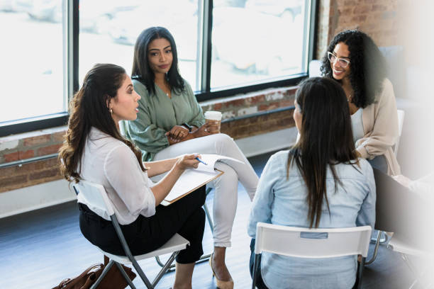 istock Group of female co-workers sit in circle for meeting 1333402637