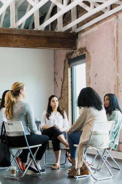 During meeting women listen attentively to youngest member During the meeting, the older women in the group listen carefully to the youngest member as she speaks. market research photos stock pictures, royalty-free photos & images