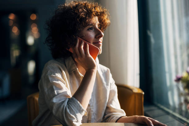 istock Smiling Business Talking on Mobile Phone in Cafe 1333403908