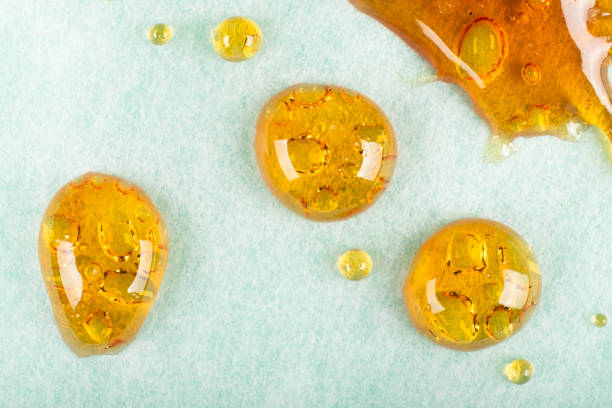 golden drops of cannabis wax macro closeup stock photo