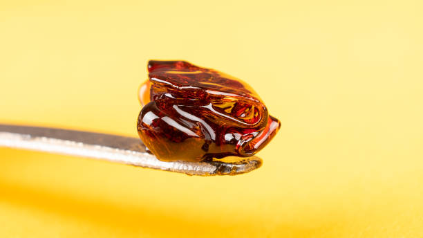 cannabis wax dab concentrate on a stick for smoking essential oils on yellow background closeup cannabis wax dab concentrate on a stick for smoking essential oils on yellow background closeup. rosin stock pictures, royalty-free photos & images
