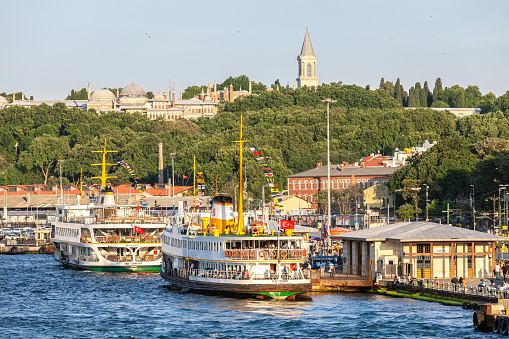 ISTANBUL, TURKEY - 07,01,2015: Ferries in Eminonu Port the Topkapi Palace on the back side Istanbul, Turkey