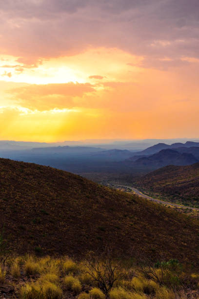 istock Sunlight shines through clouds creating an orange sky above the mountains. 1333406524
