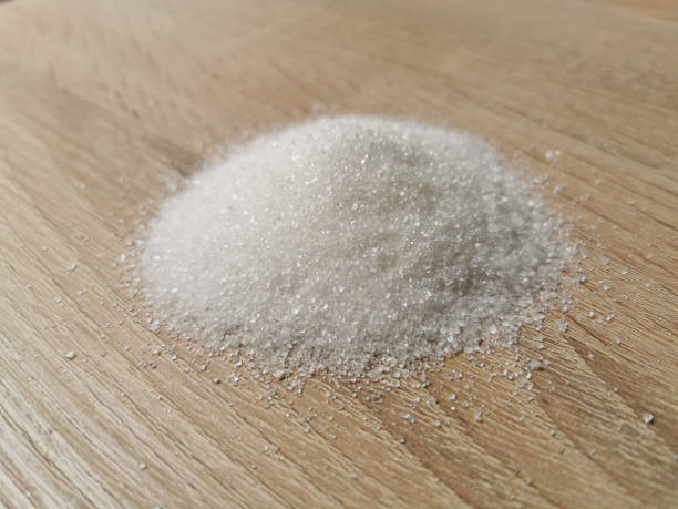 istock Pile of granulated white sugar on wooden table 1333409038
