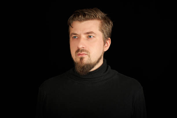 istock Cute bearded man, half-profile portrait, black background 1333409211