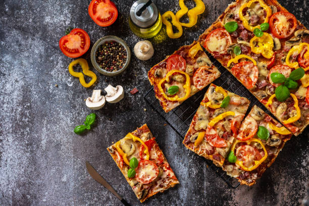 Homemade baking Detroit-Style pizza. Large rectangular Pepperoni pizza with mushrooms, salami and cheese on a stone tabletop. Top view flat lay background. Copy space.