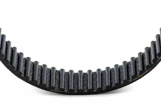 A macro photo of a toothed belt, isolated on a white background.