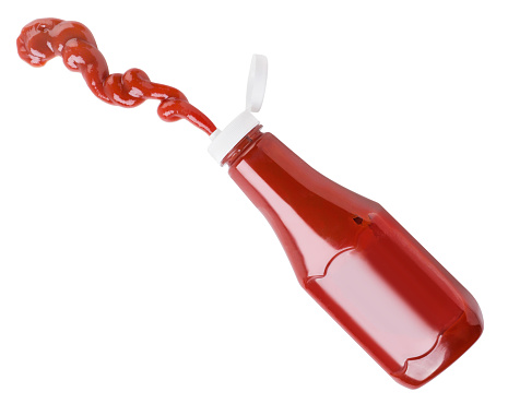 Ketchup flies out of a bottle close-up on a white background, cut. Isolated