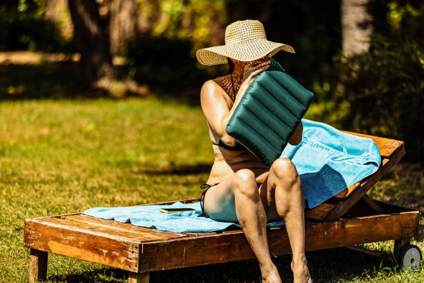 Woman is preparing to sunbathe in her backyard