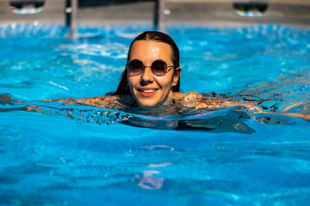 istock Pretty woman relaxing at pool 1333429673