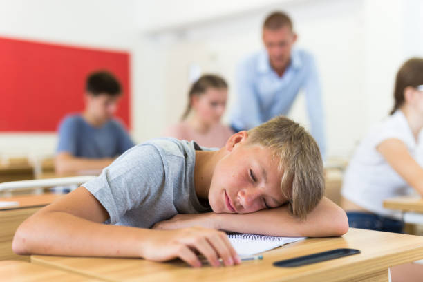 istock Teenager boy lying on desk 1333429755