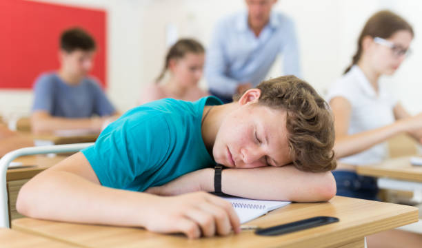 istock Teenager boy lying on desk 1333429761