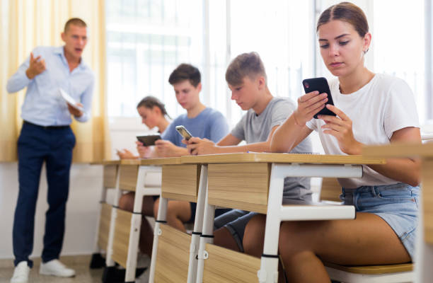 istock Teen pupils using mobile phones during lesson 1333430067