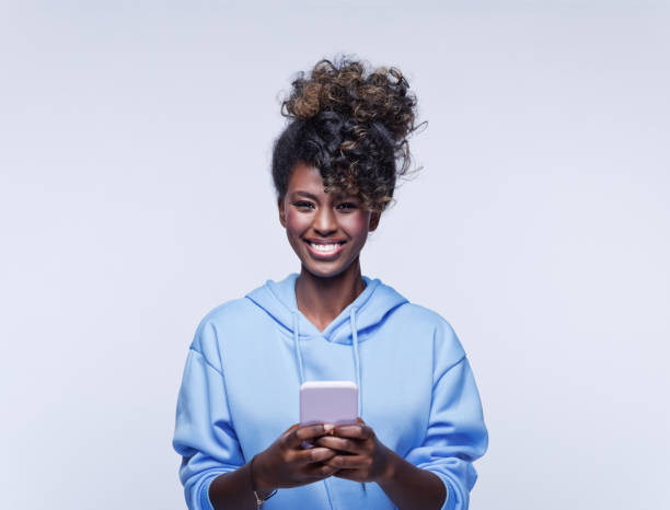 istock Cheerful young woman using mobile phone 1333430387