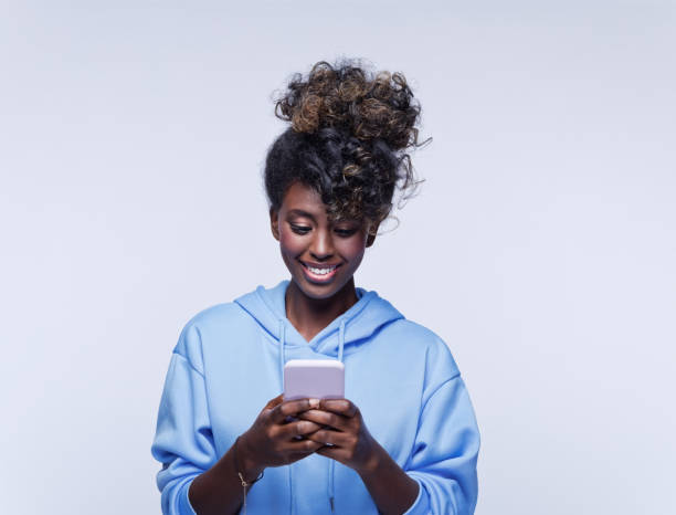 istock Cheerful young woman using mobile phone 1333430473