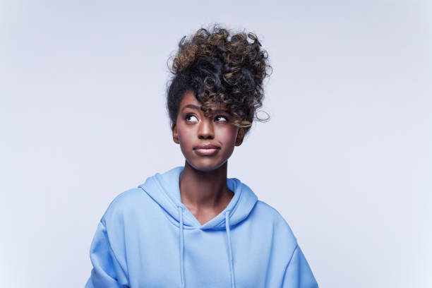 confused young woman in blue hoodie - choice thinking women decisions imagens e fotografias de stock