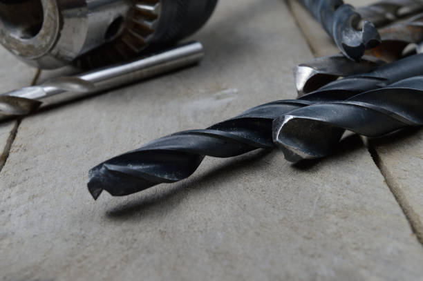 istock replaceable drill chuck and old drill bits lie on a wooden plank background. close-up. 1333432323