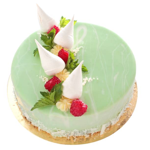 Green cake with raspberries, meringue and mint. Studio photo close-up on a white background.