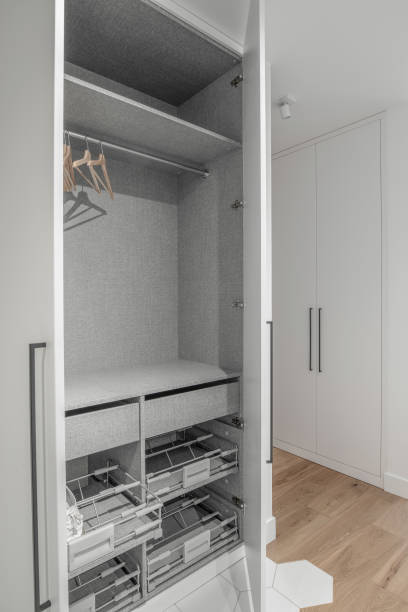 istock New empty modern closet wardrobe shelves by grey finish  material and opened doors. Closet with hangers and rail rack 1333433650